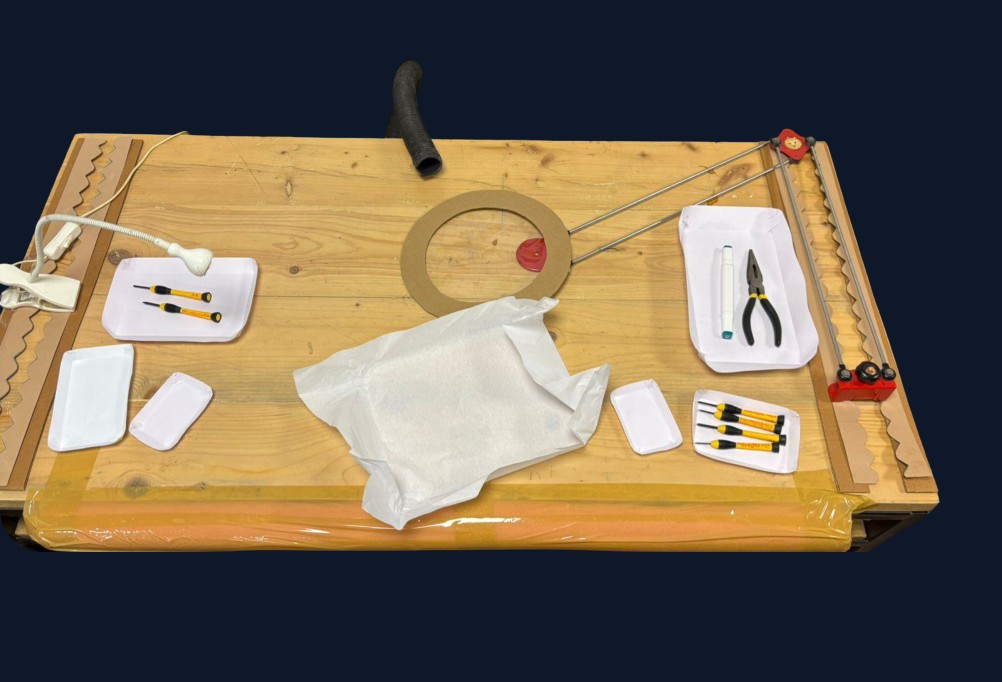 Close-up of a redesigned workbench pegboard with lens-fitting tools laid out