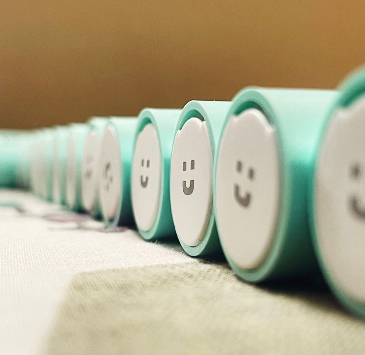 Close macro row of TUSK toothbrush heads with printed smiley faces